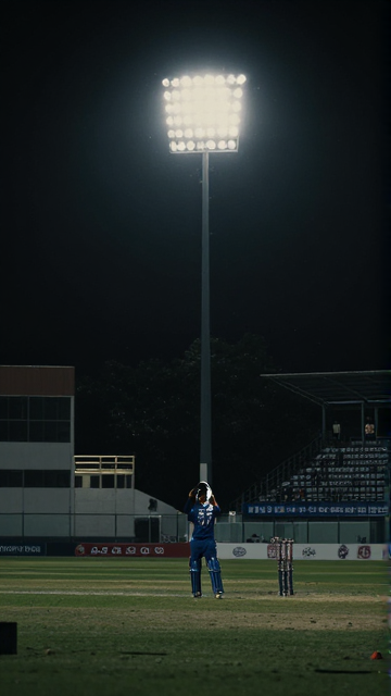 Batter under stadium floodlights at night